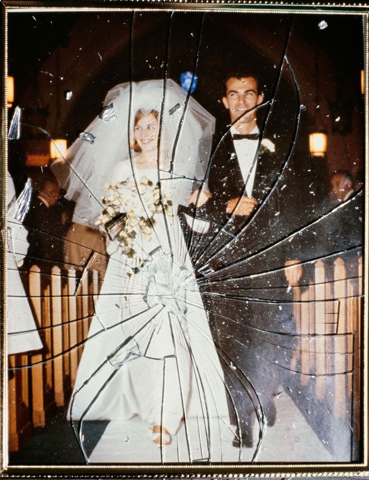 Ein gerahmtes Hochzeitsfoto hinter zersprungenem Glas